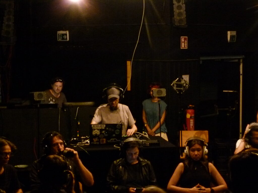Audience wearing open headphones during an augmented spatial music performance eith the HADS.